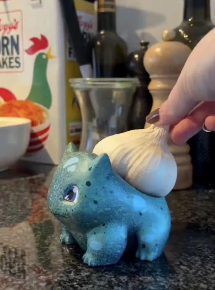 Blue ceramic Bulbasaur used as a garlic holder in minimalist kitchen design