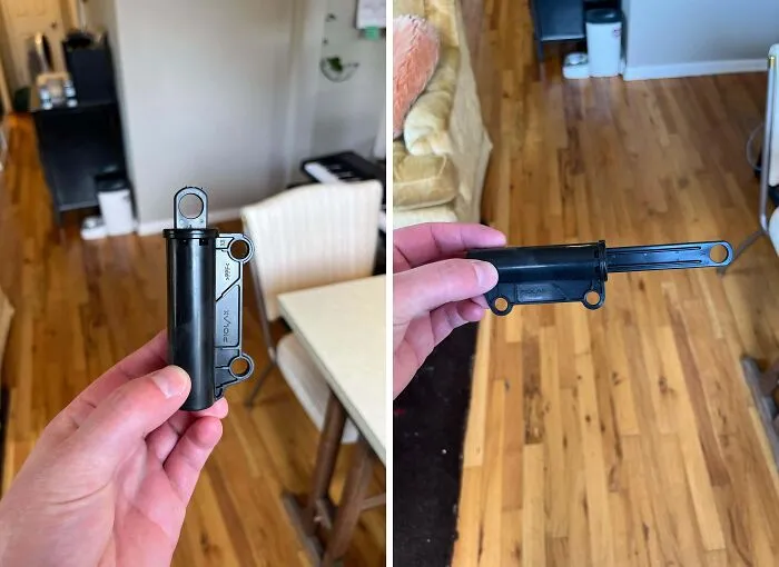 Hand holding unidentified black plastic object with pulled-out sliding part on wooden floor, internet mystery solved.