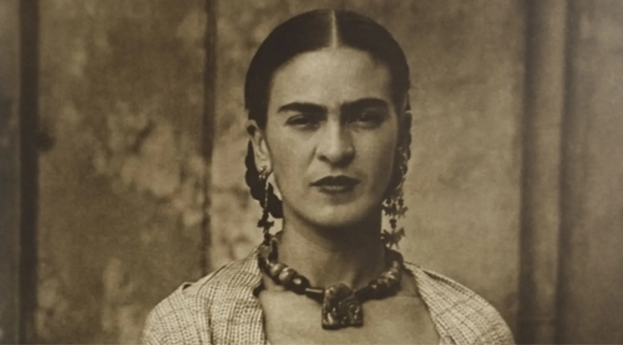 Sepia photo of famous artist known for her self-portraits and distinctive style wearing traditional jewelry and clothing.