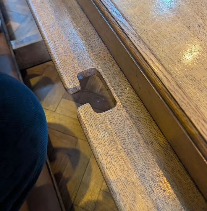 Close-up of a wooden bench with a carved notch, one of the internet solved mystery of unidentified objects.