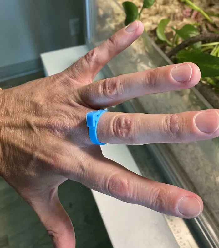 Close-up of a hand wearing a blue plastic ring, an example of the internet solving the mystery of unidentified objects.