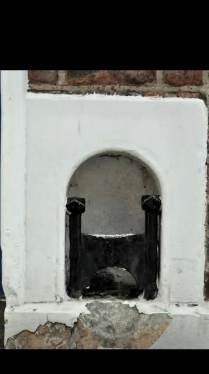 ¿Qué es esto que está integrado en la pared de una vieja casa de ladrillo?