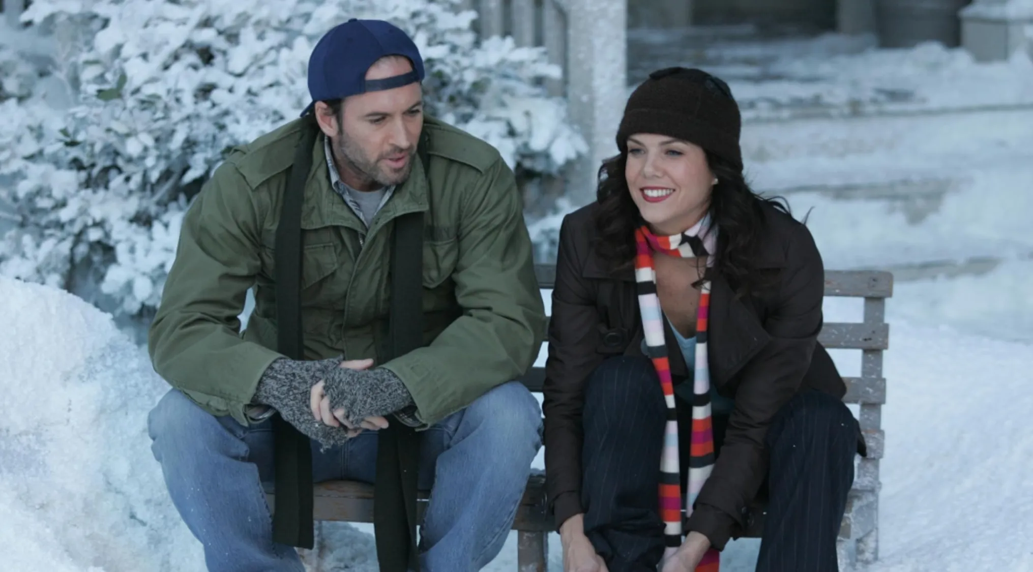 Fictional couples quiz featuring a man and woman sitting on a bench outdoors in snowy winter setting.