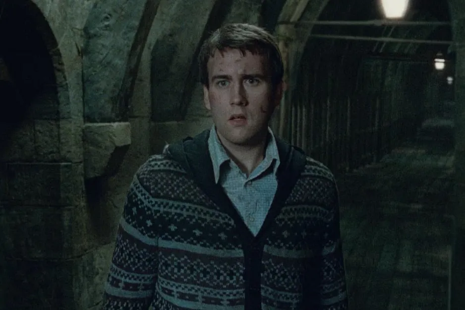Young man resembling Neville Longbottom in a dimly lit stone corridor, reflecting Harry Potter series atmosphere.