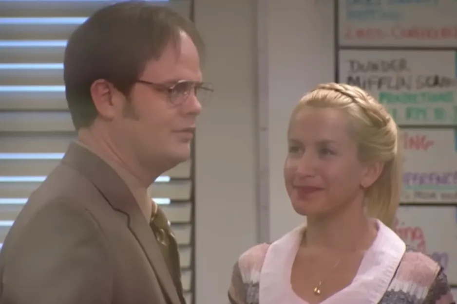 A man in glasses and a woman with braided hair smiling indoors, related to Harry and Sally from When Harry Met Sally image.