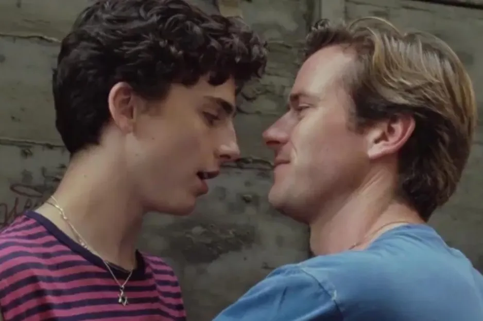 Couple from Call Me By Your Name movie sharing a close moment, one wearing a striped shirt, the other in a blue shirt