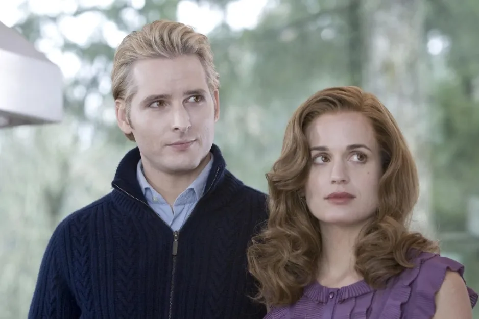 Couple from The Vampire Diaries dressed in vintage style with serious expressions standing outdoors in natural light.