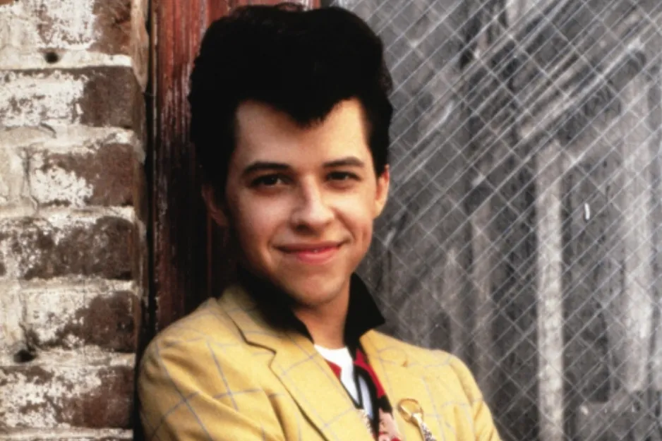 Young man in a yellow jacket smiling, representing who Andie ends up with in Pretty in Pink movie.