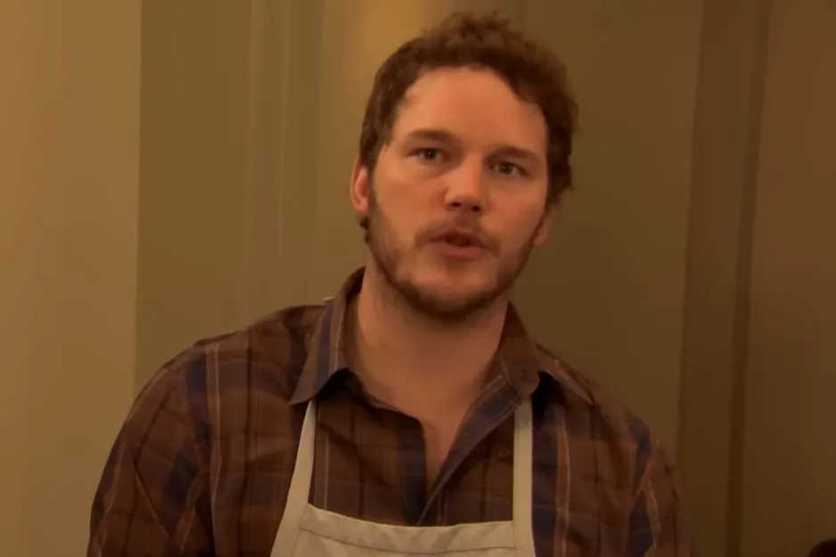 Actor Chris Pratt as the guy who becomes Leslie Knope's husband in Parks and Recreation wearing a plaid shirt and apron.