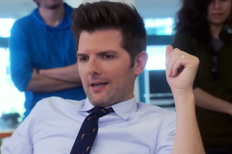 Male character from Parks and Recreation wearing a shirt and tie, engaged in conversation about Leslie Knope's husband.