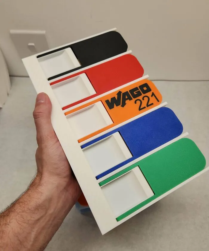 Hand holding a custom 3D printed organizer for questionable DIY projects.