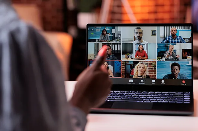 Person attending an online webinar on laptop with multiple participants visible, engaging in a weekend hobby discussion.