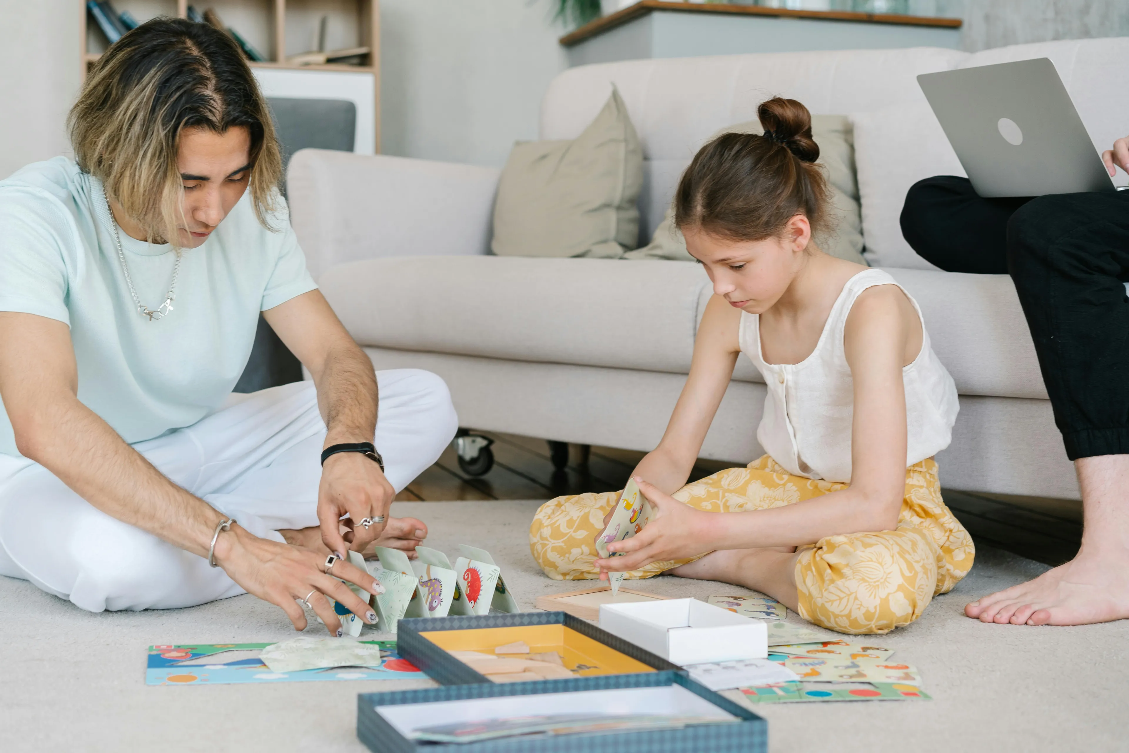 Two children playing family board games on the floor as a fun rainy day activity indoors.