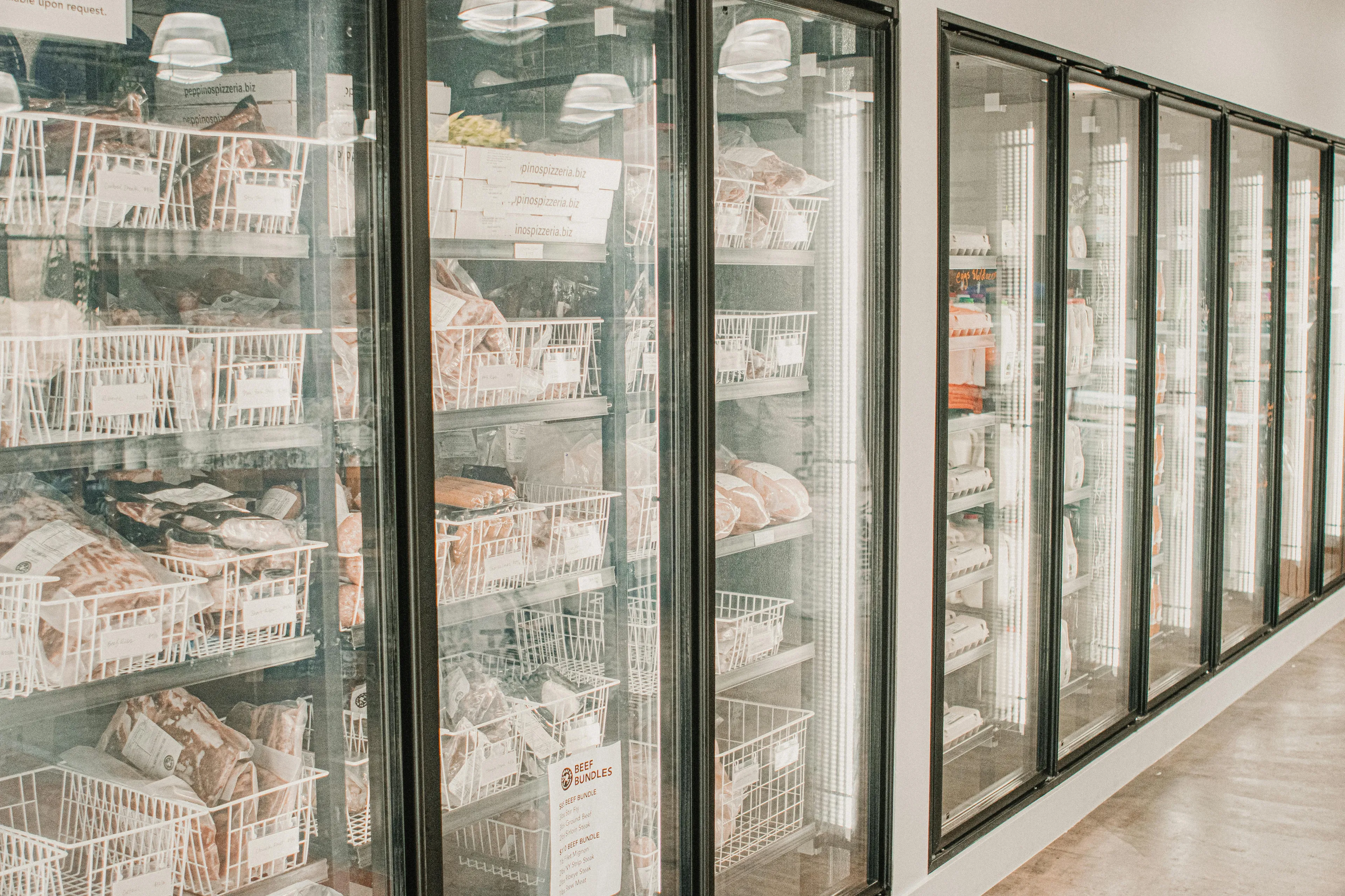 Rows of commercial freezer doors in a store, illustrating freezer and room temperature changes over time when door is open.