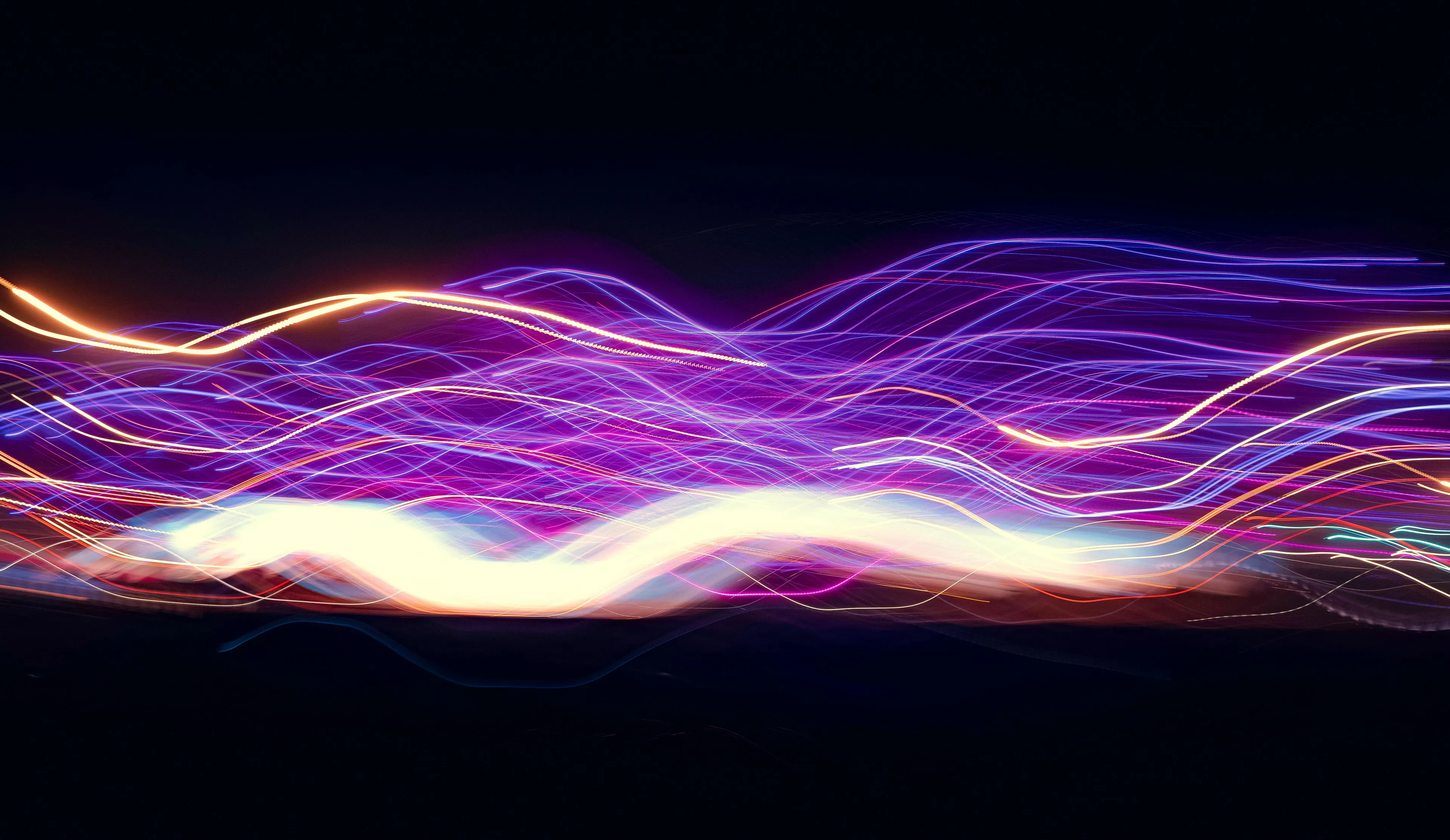 Colorful light waves in motion against a dark background illustrating waves that require a medium to travel.