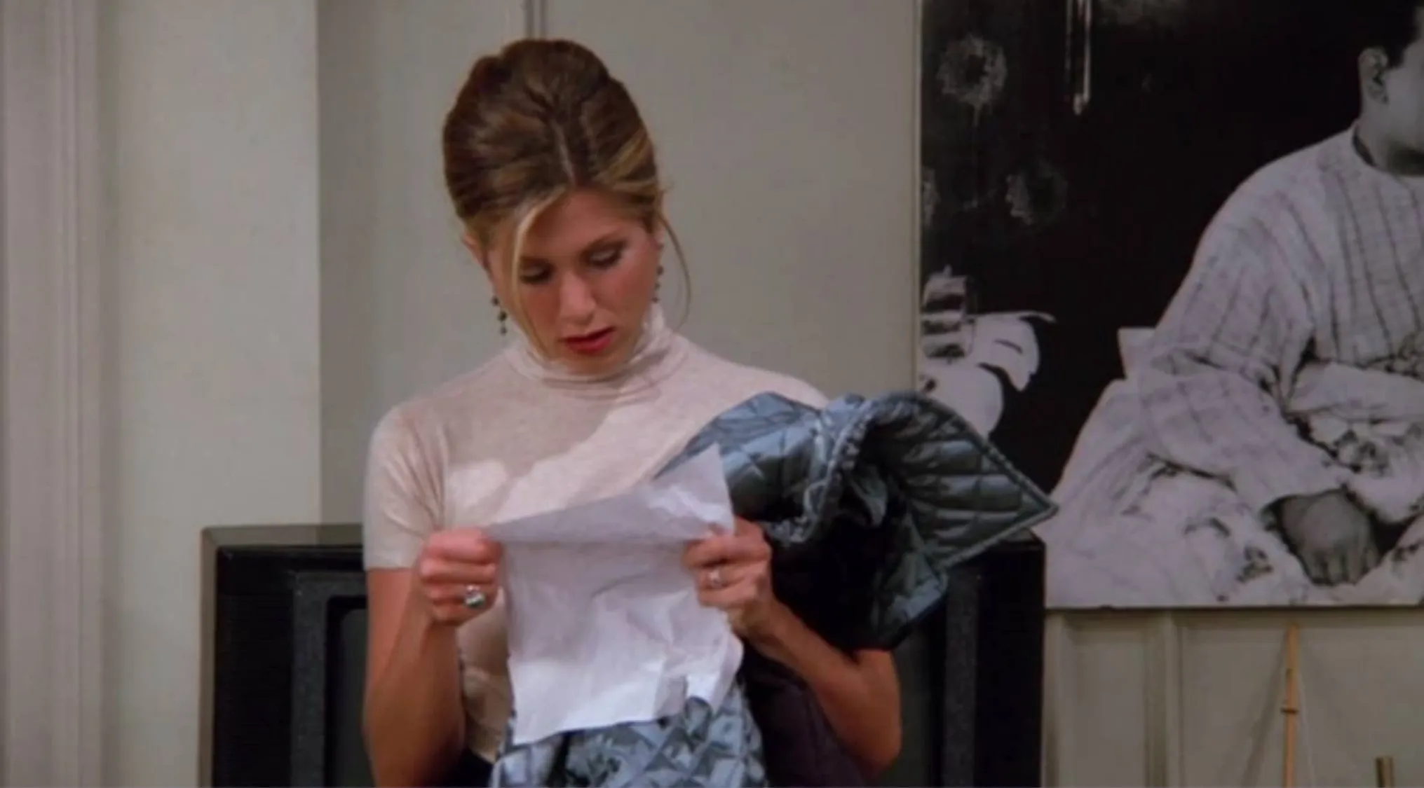 Rachel from Friends reading a crumpled paper, related to Ross's infamous cons list in the sitcom Friends.