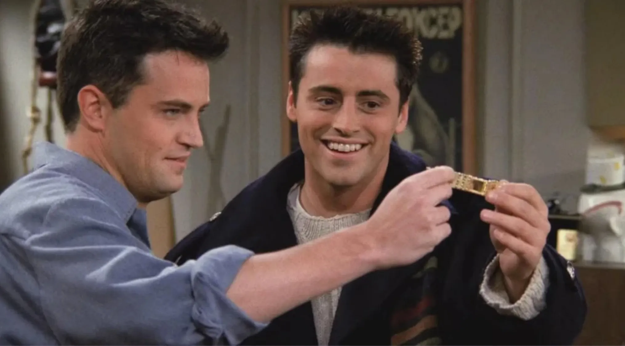 Joey and Chandler examining the bracelet with the engraved message, proving the ultimate Friends fan knowledge.