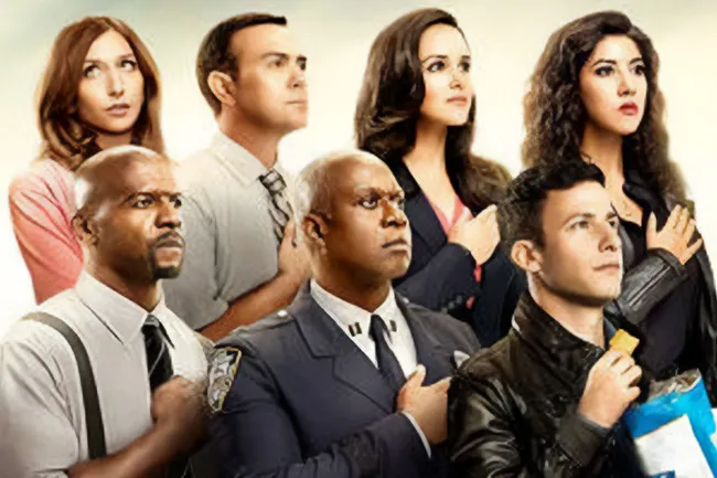 Cast of Brooklyn Nine-Nine standing with hands over hearts in a patriotic pose, promoting a comfort TV rerun.