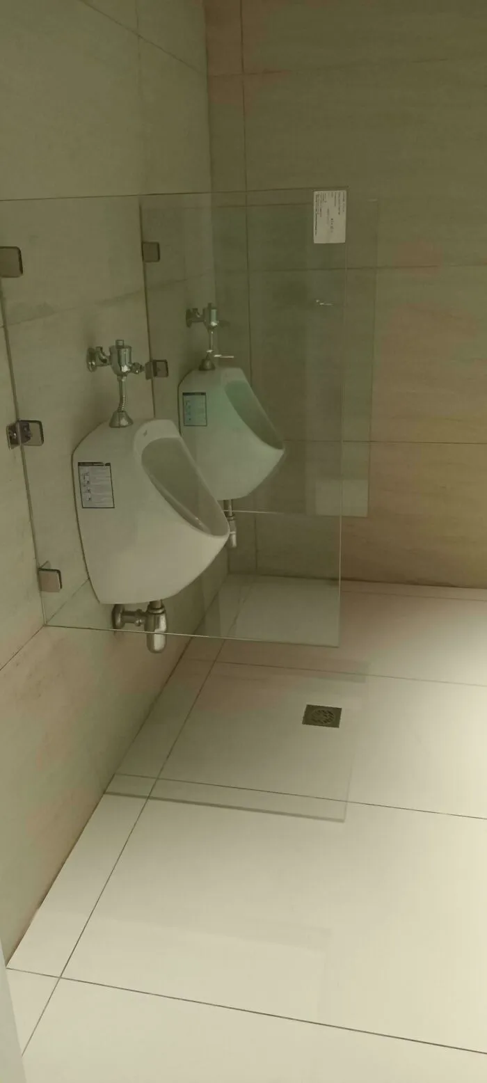 Mampara de cristal totalmente transparente para urinario. Más estúpida que interesante, en mi opinión.