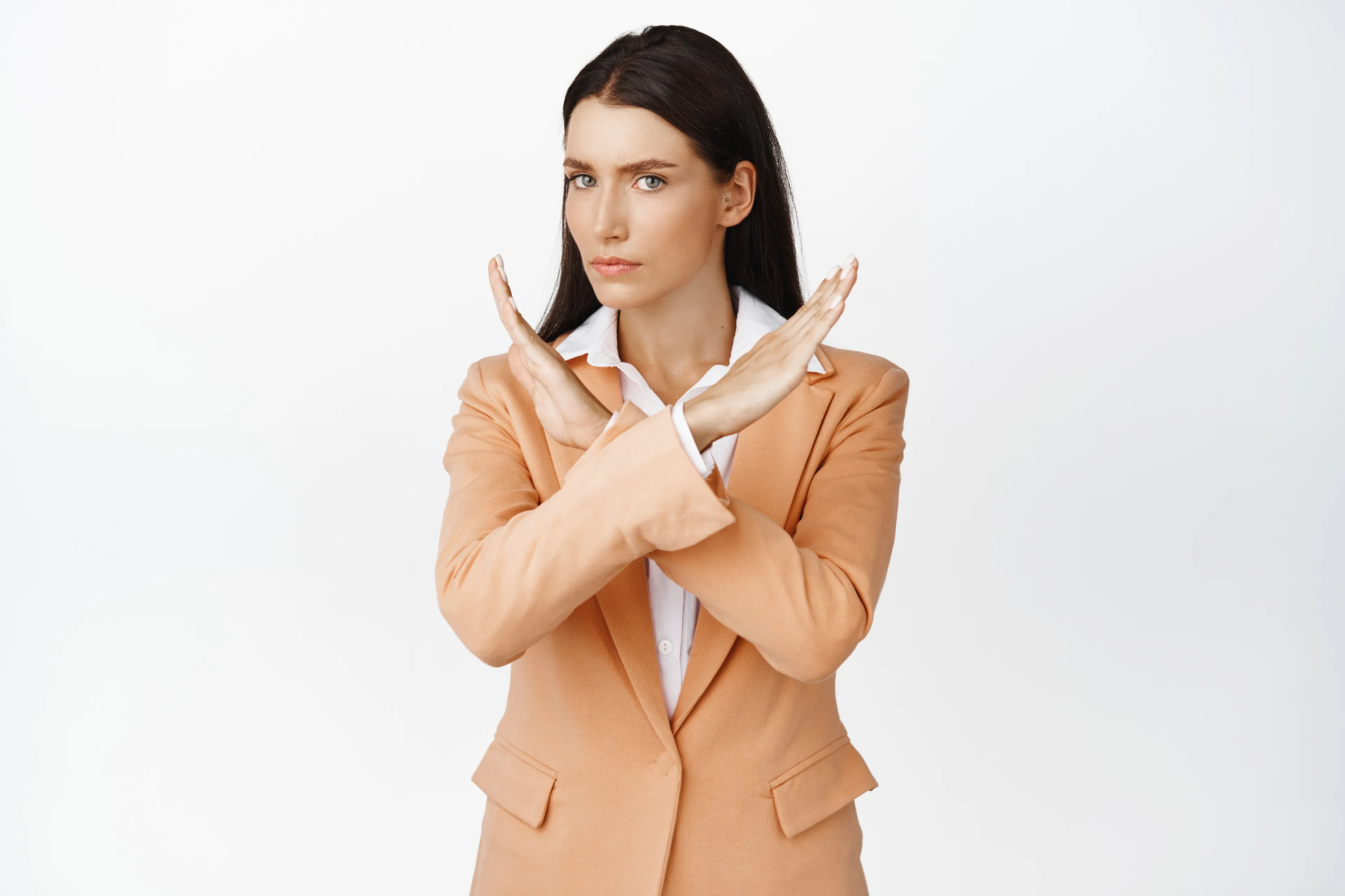 Woman in a tan blazer showing a crossed-arms gesture, representing boundary style personality quiz concept.