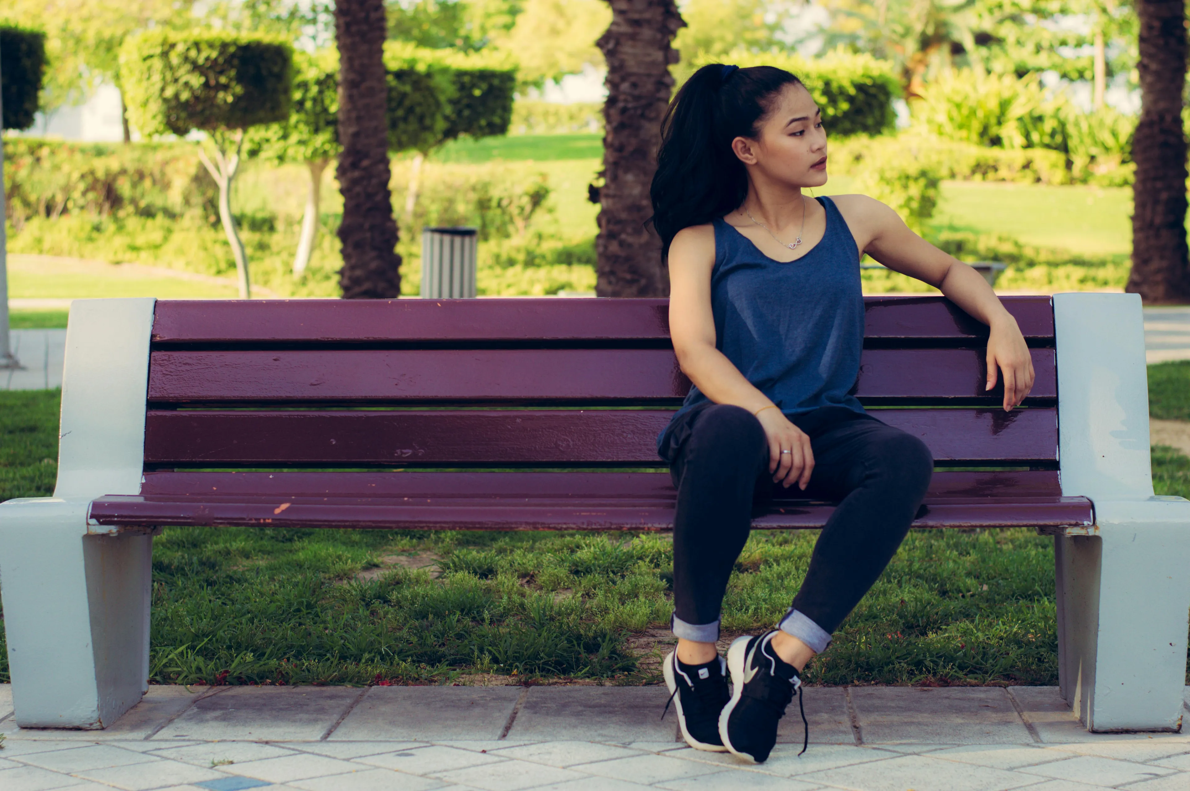 A woman on a park bench looking to the side, illustrating boundary style personality in social situations.