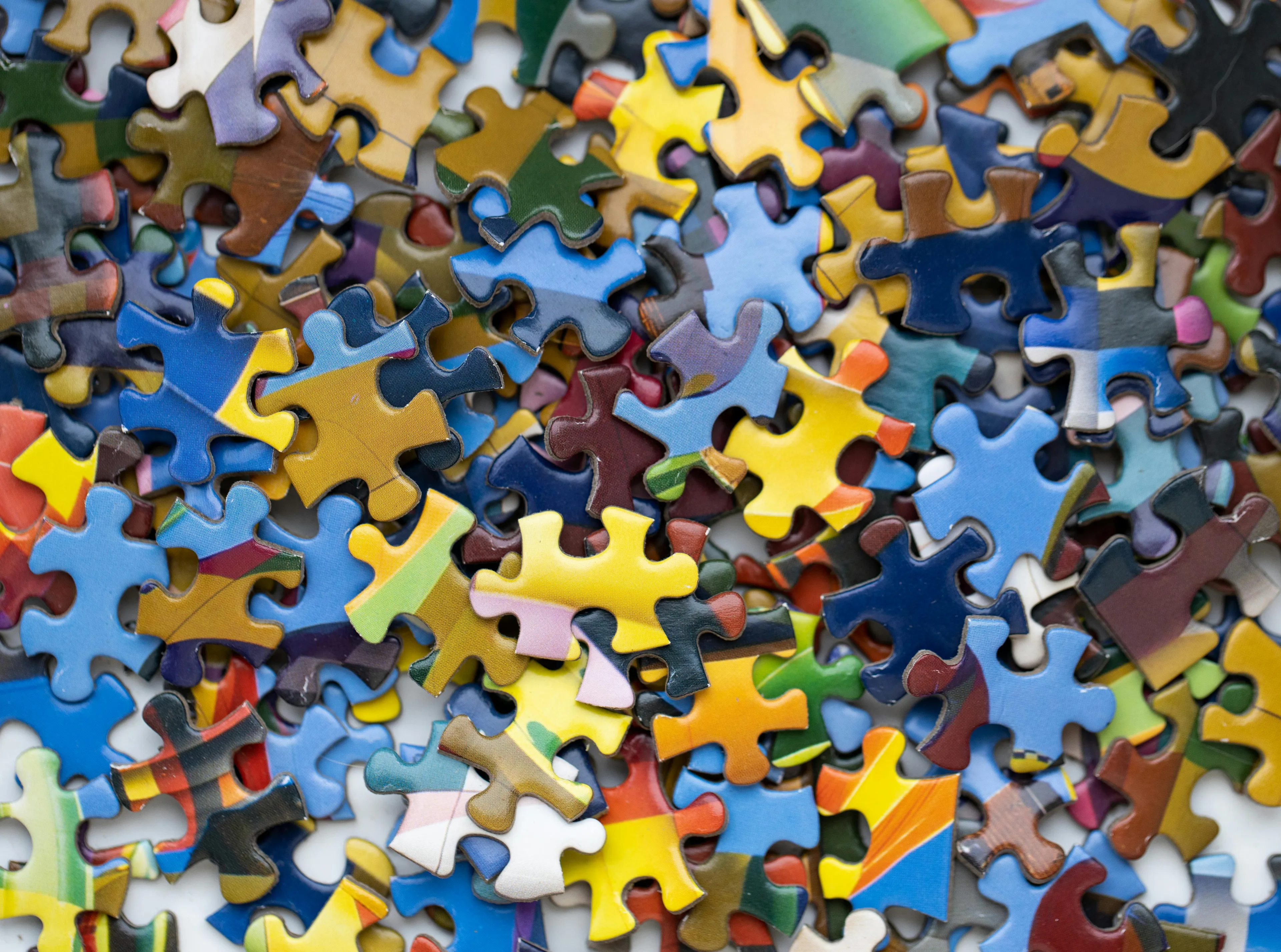 Close-up of colorful puzzle pieces scattered, perfect for puzzle marathons as a weekend hobby activity.