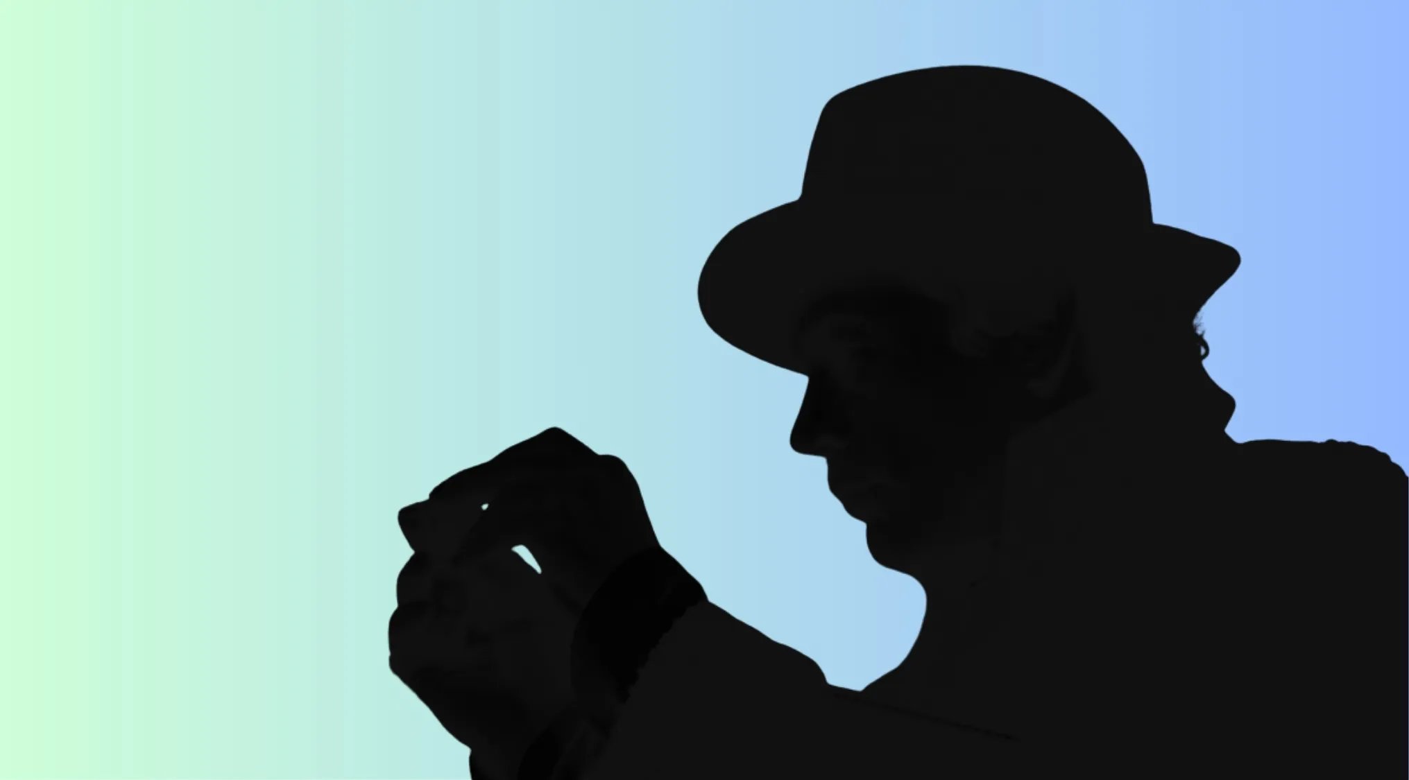 Silhouette of a movie character wearing a hat, holding an object, inviting viewers to guess who the character is.