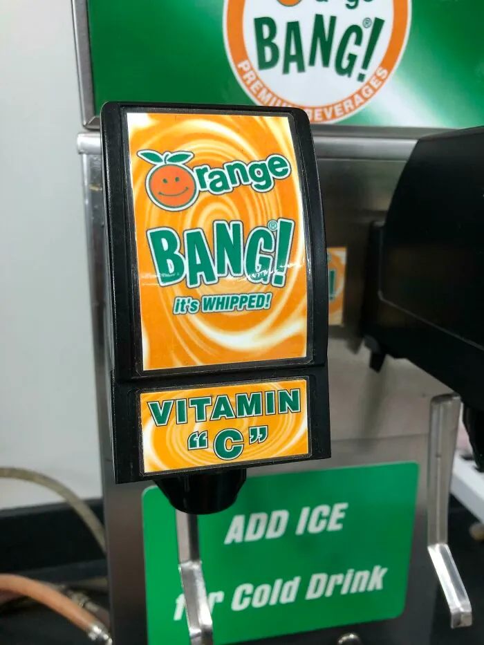 Orange BANG soda dispenser with a sign putting suspicious quotation marks around Vitamin C.