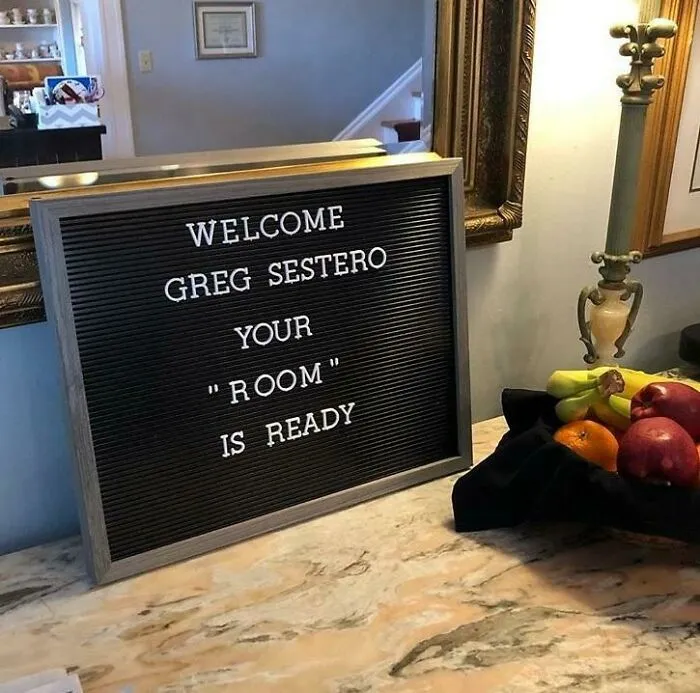 Letter board with hilariously suspicious use of quotation marks around the word room, placed on a marble countertop with fruit nearby.