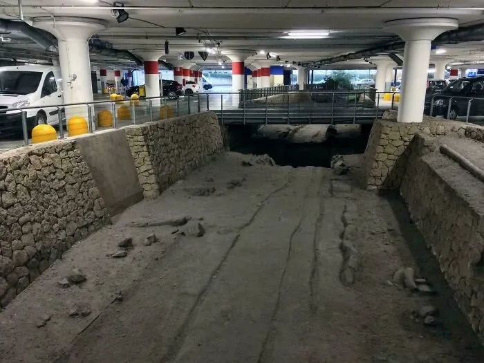 An ancient Roman road preserved inside a modern parking garage, one of many historical finds.