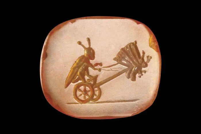 Carved gemstone seal showing a bug driving a butterfly chariot, a unique historical find.