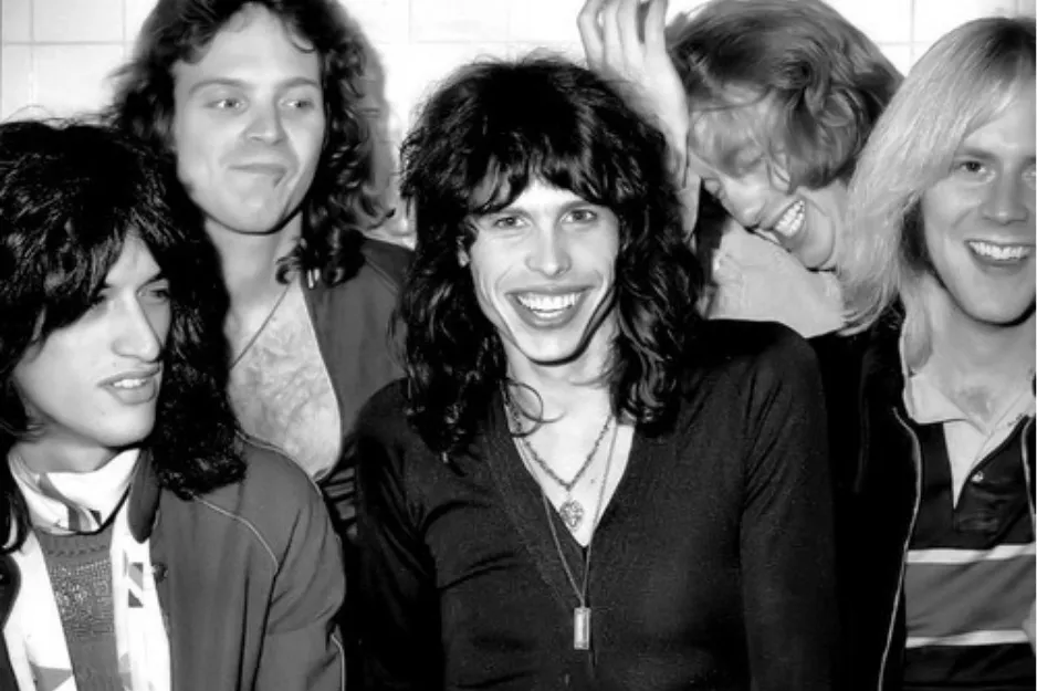Black and white photo of the rock band Bon Jovi smiling and posing together in a casual setting.