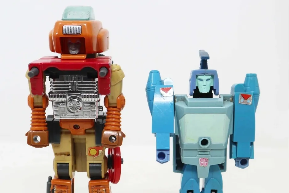 Vintage robots and Transformers toys from the 1980s displayed against a plain white background.
