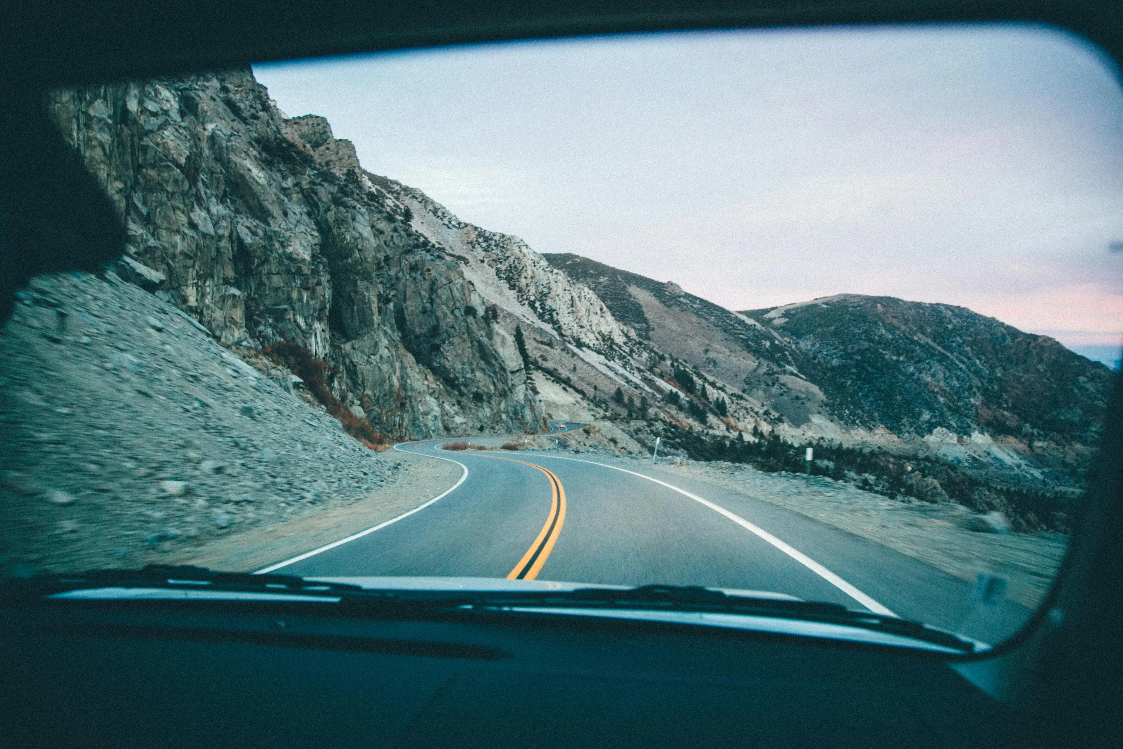 View from inside a car on a winding mountain road, illustrating decision making style decoder for choosing routes.