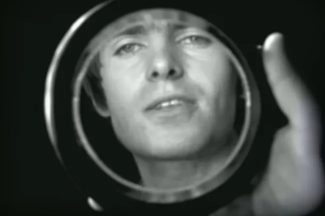 Close-up of a person reflected in a circular mirror, symbolizing choosing music for a dinner party with Wonderwall by Oasis.