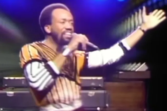 Singer from Earth Wind and Fire performing on stage, related to choosing music for a dinner party playlist.