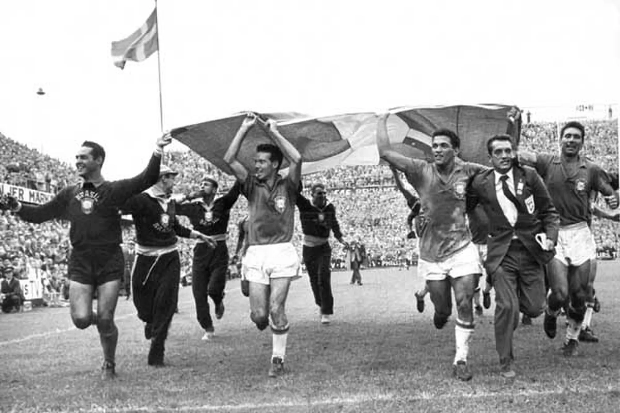 Brazilian footballers celebrating on the field holding a flag after winning the 1958 FIFA World Cup in Sweden.