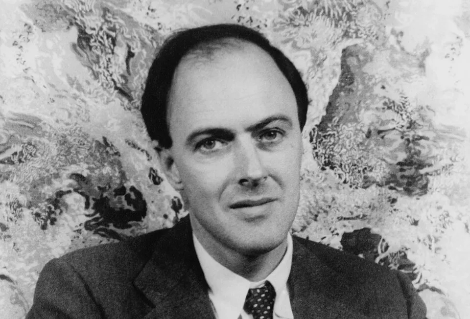 Black and white portrait of a British author in a suit and tie with a patterned background, related to The Lord of the Rings trilogy.