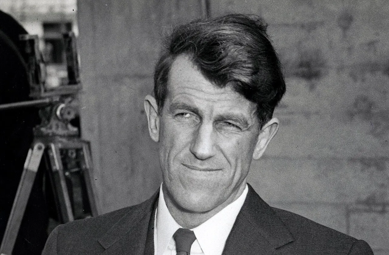 Black and white portrait of New Zealand mountaineer Edmund Hillary in a suit, looking confidently to the side.
