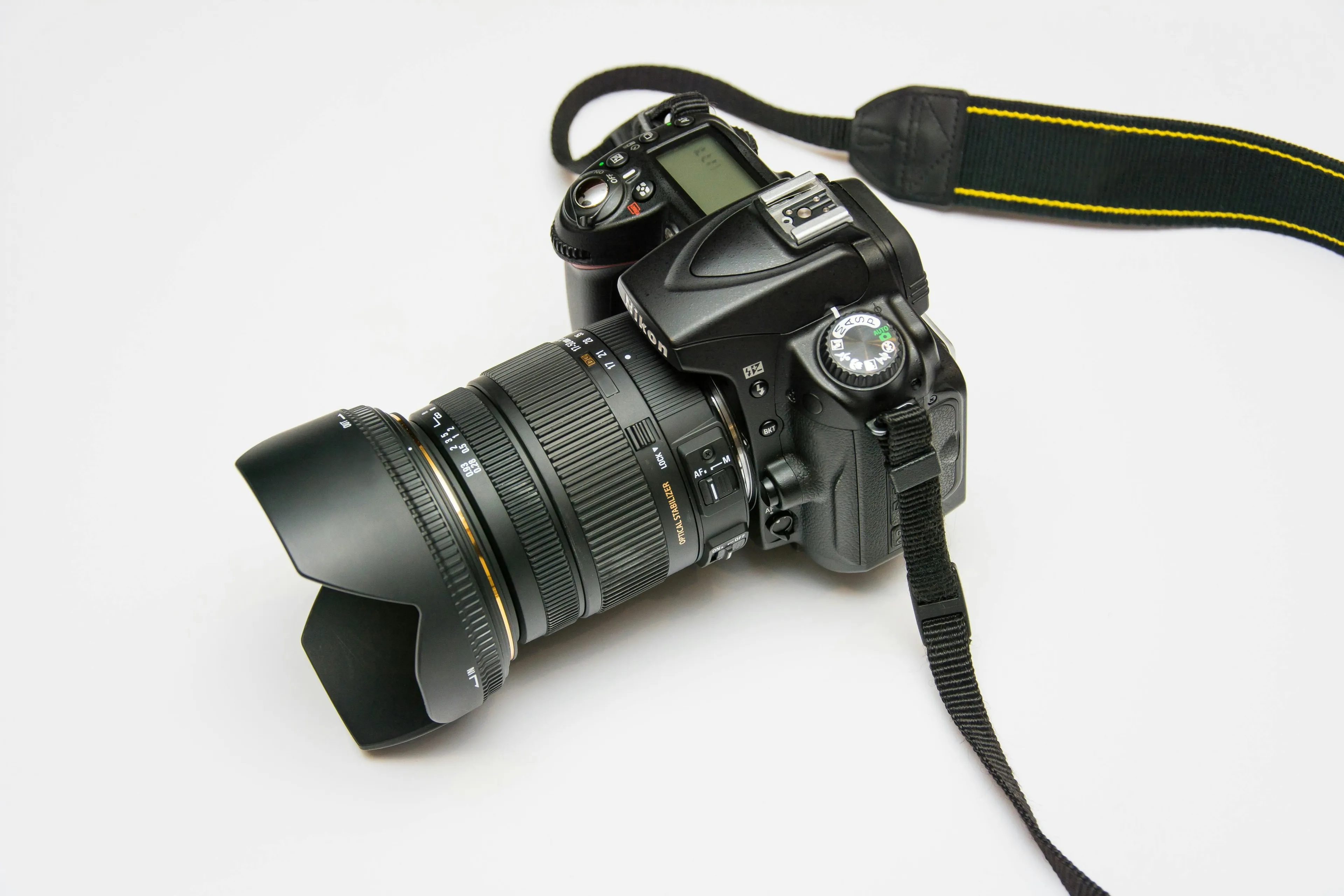DSLR camera with wide-angle lens and strap on a white background, perfect for photography hobby enthusiasts.