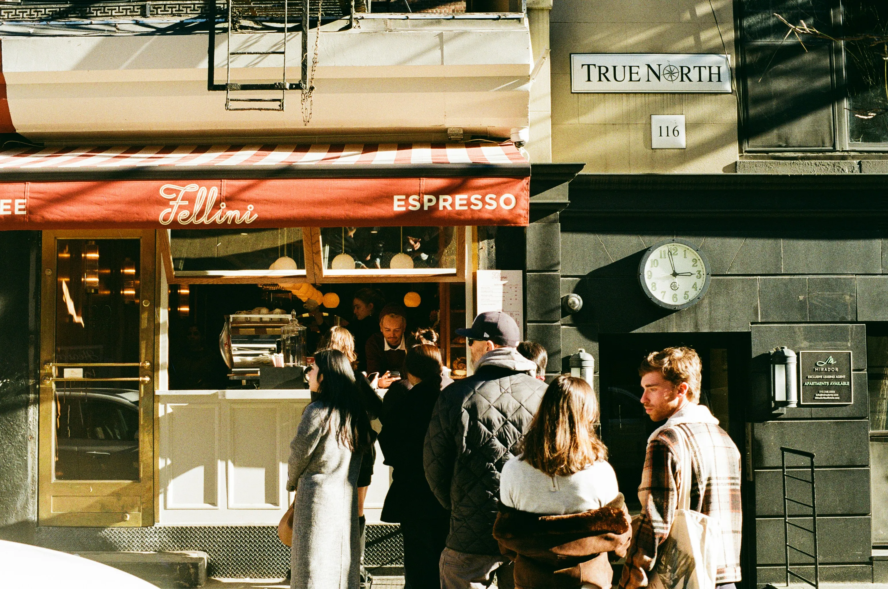 People waiting in line outside a café, highlighting the challenge of controlling urges when someone cuts the line.