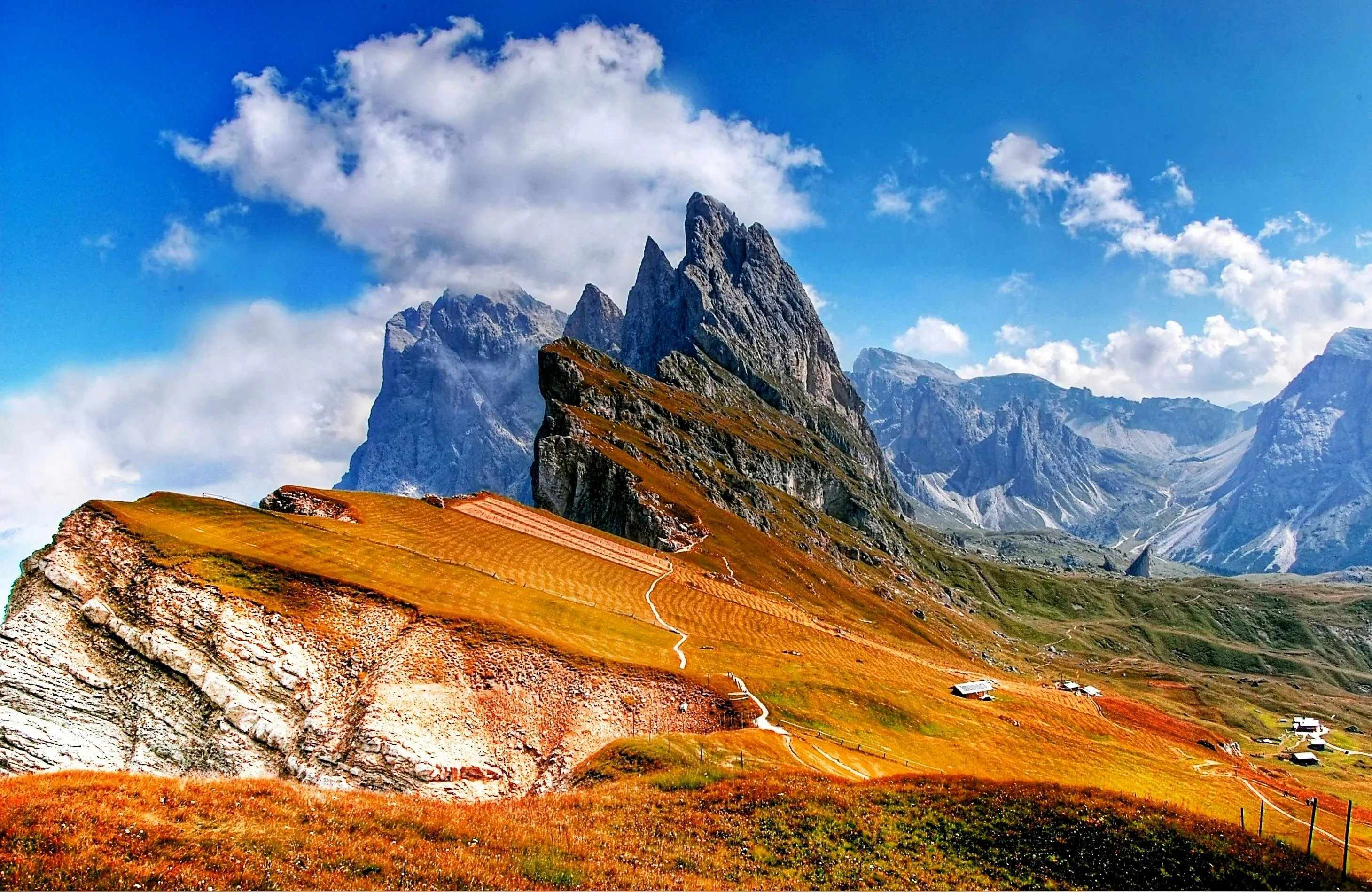 Scenic mountain landscape with winding paths under a bright blue sky, testing can you control your urges while driving.