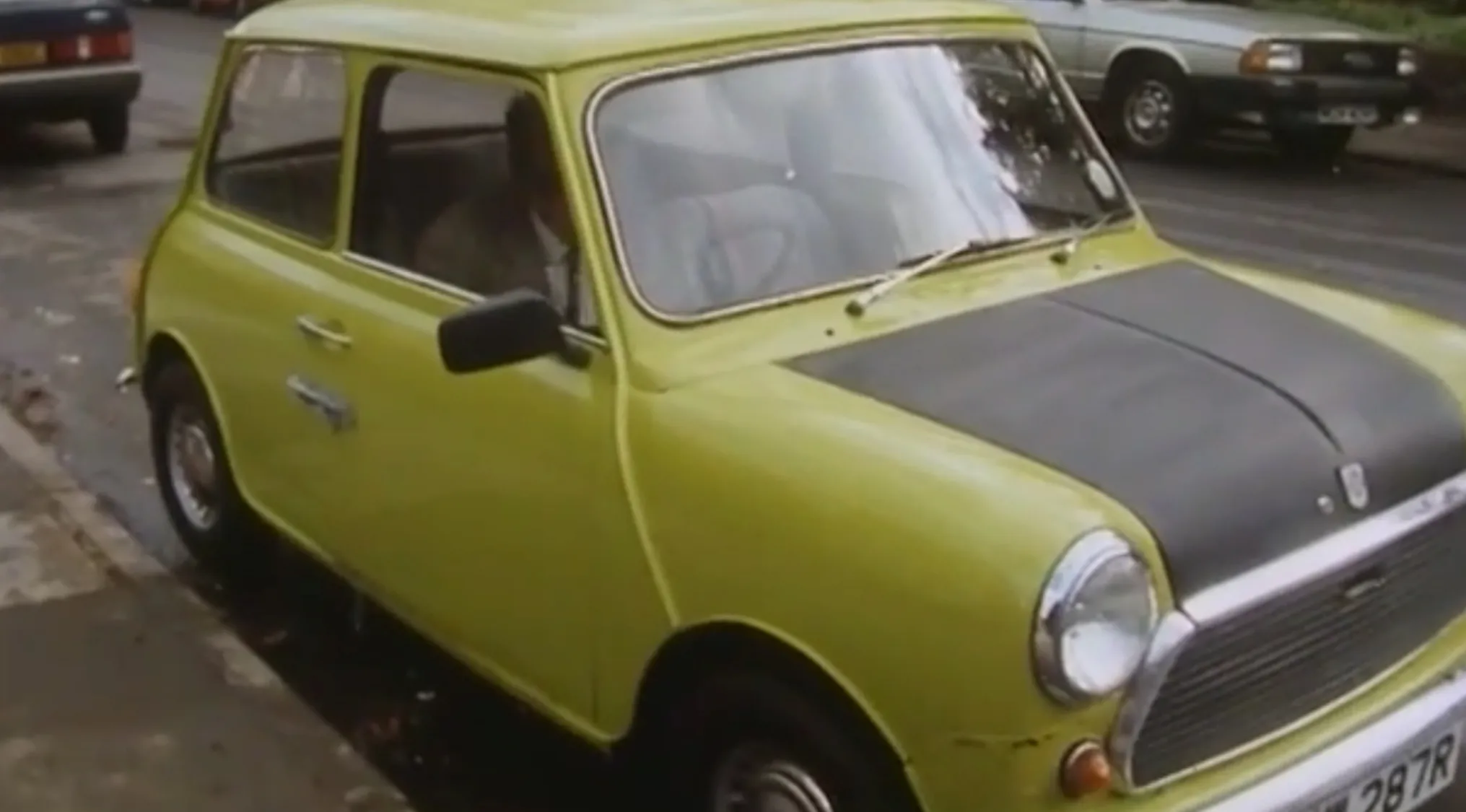 Yellow vintage compact car parked on the street as part of TV show props quiz car scene.