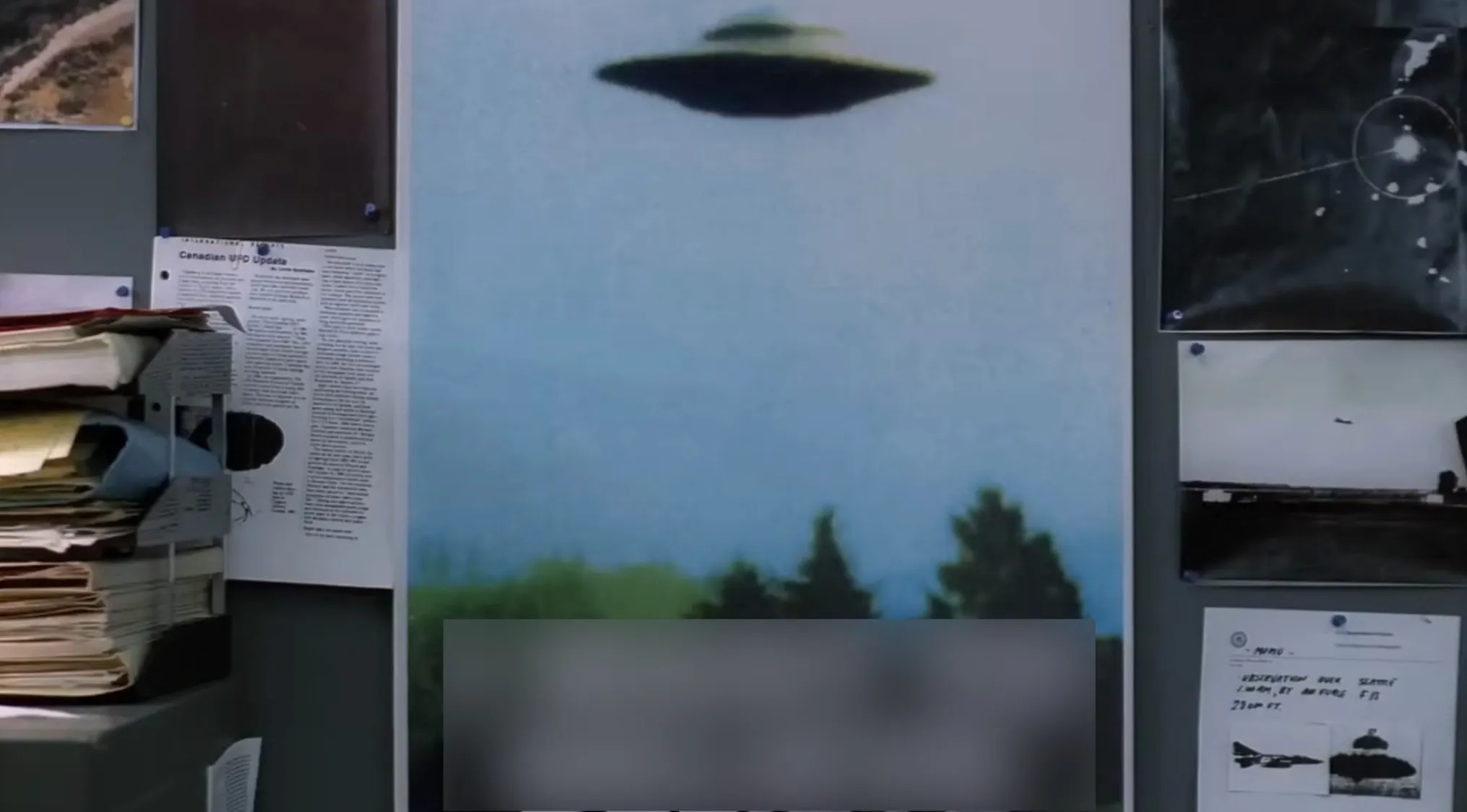 Poster in Fox Mulder's basement office featuring a UFO and surrounding papers in The X-Files TV show props quiz.