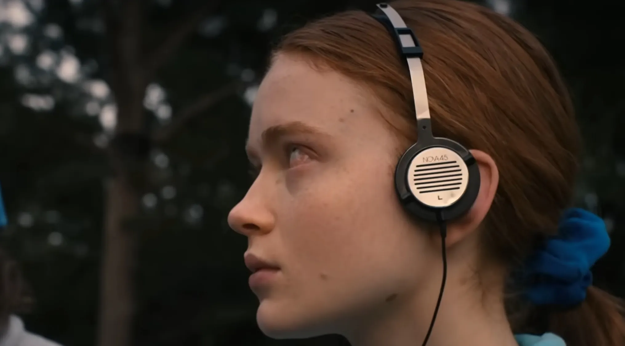 Close-up of Max from Stranger Things wearing vintage headphones, a key TV show prop in the survival storyline.