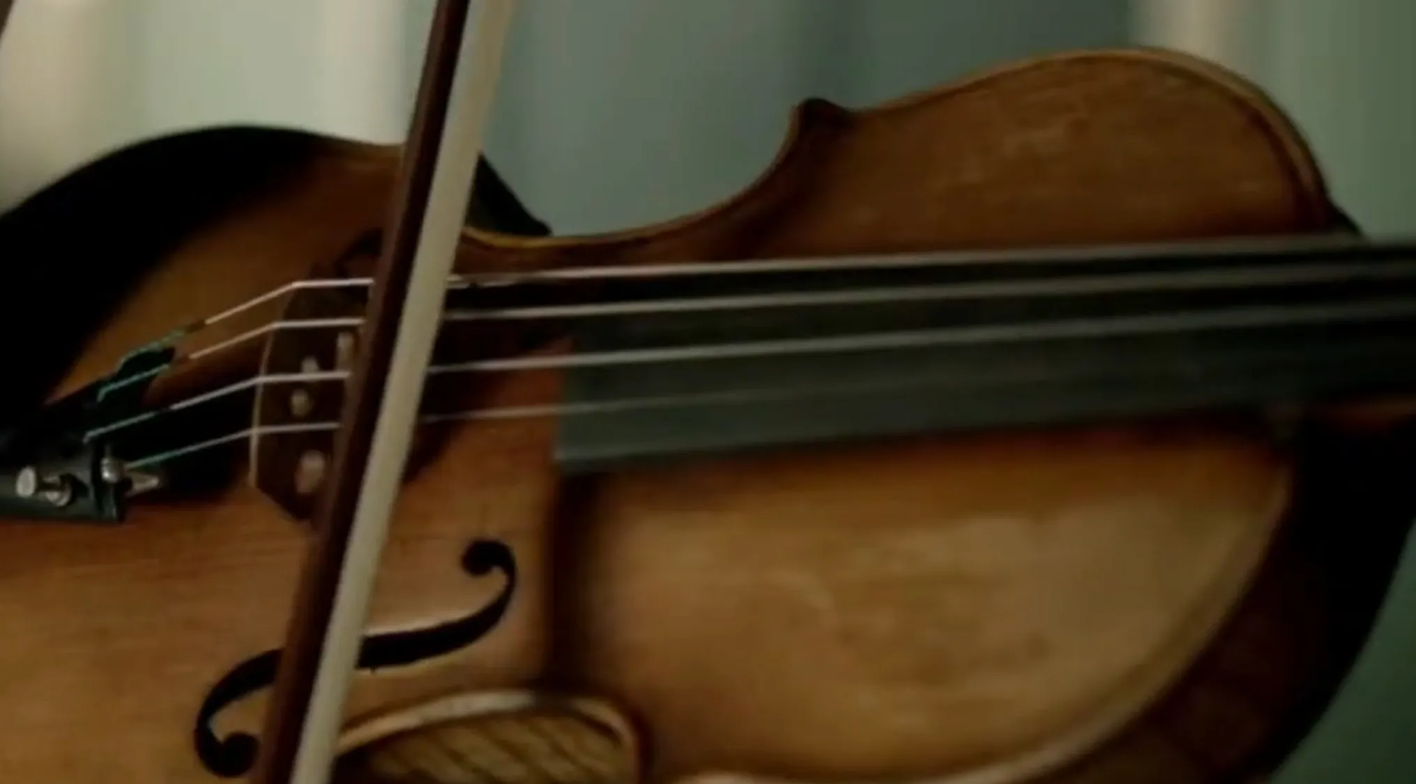 Close-up of a violin being played in a TV show props quiz featuring a detective playing violin when thinking.