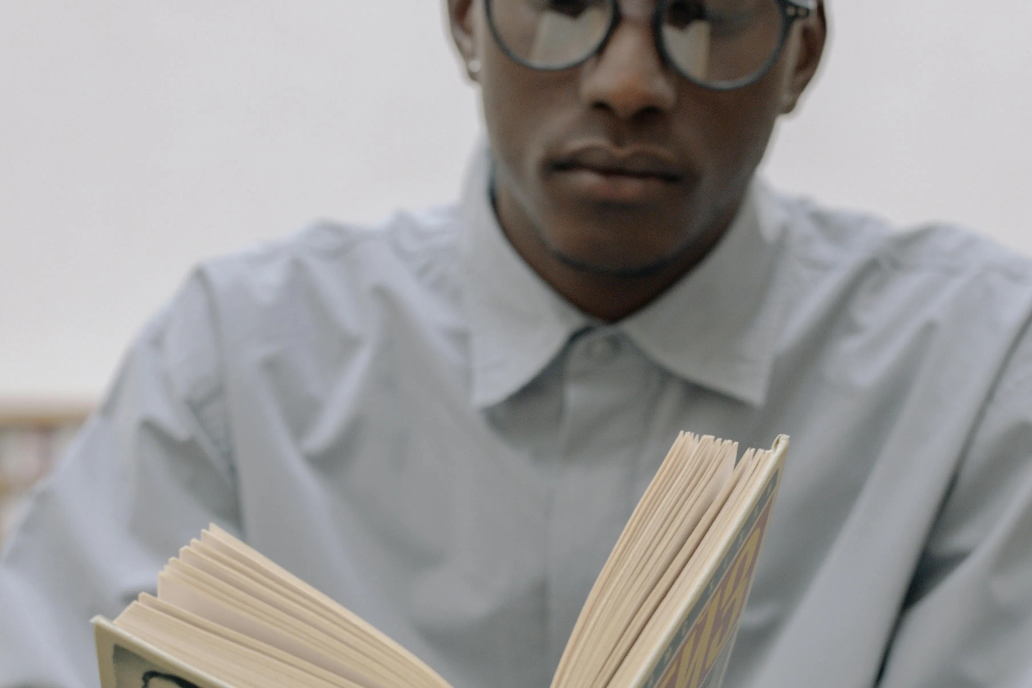 Student reading a book focused on advanced placement school quiz and English literature concepts.