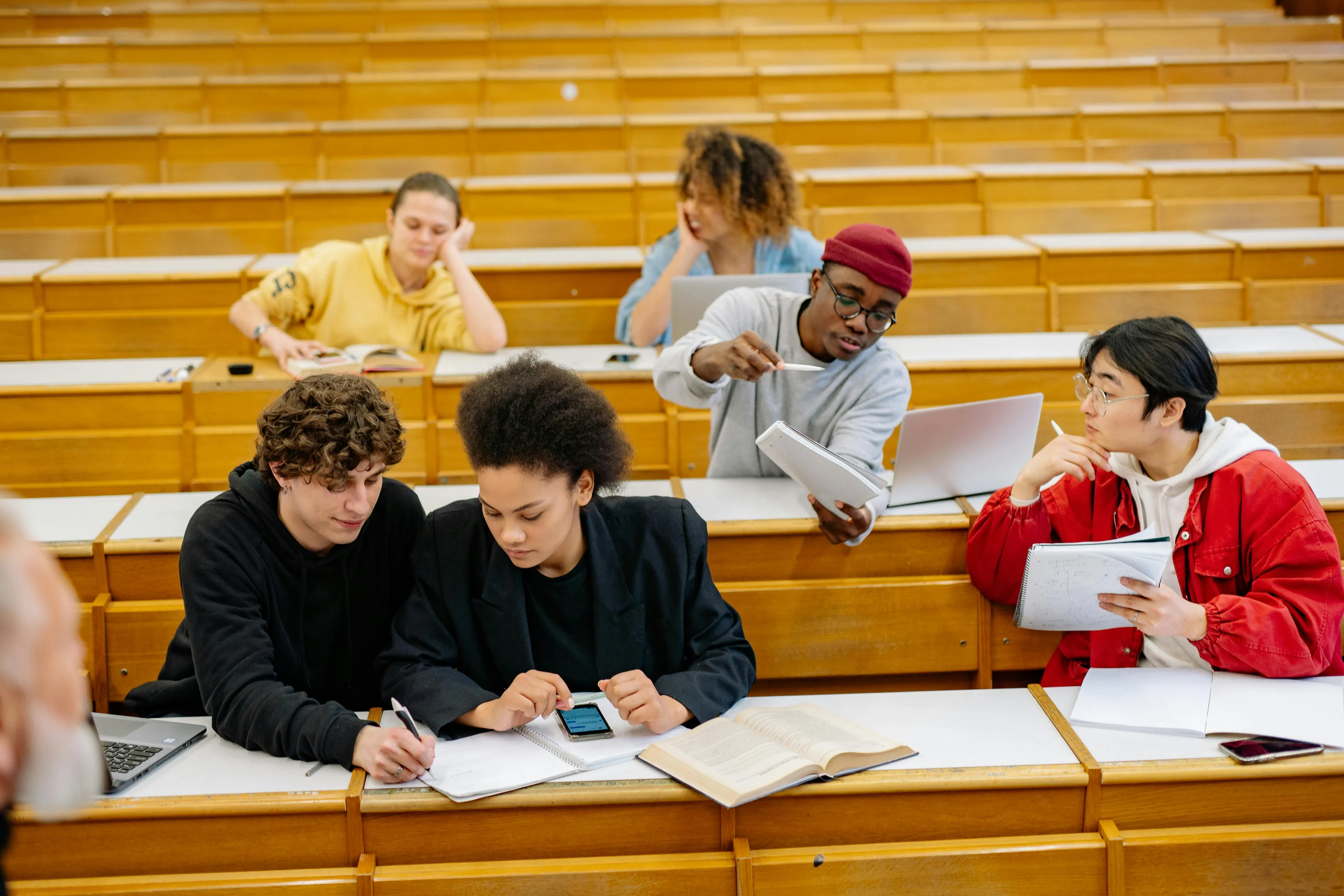 Students in a classroom discussing statistics concepts, focusing on the best measure of central tendency with outliers.