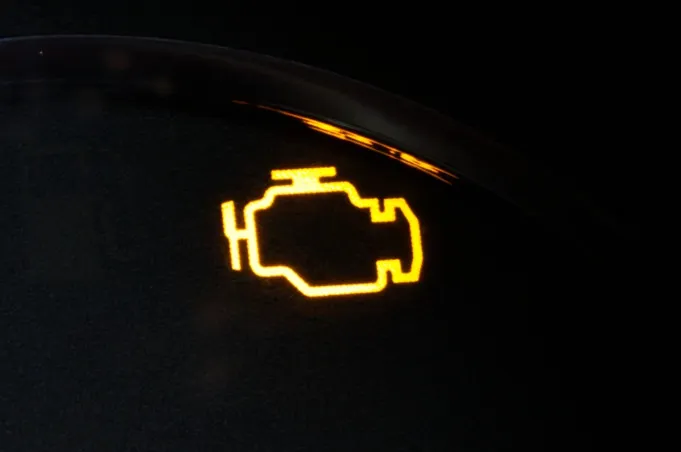 Check engine light illuminated on car dashboard symbolizing decision making style decoder scenario.