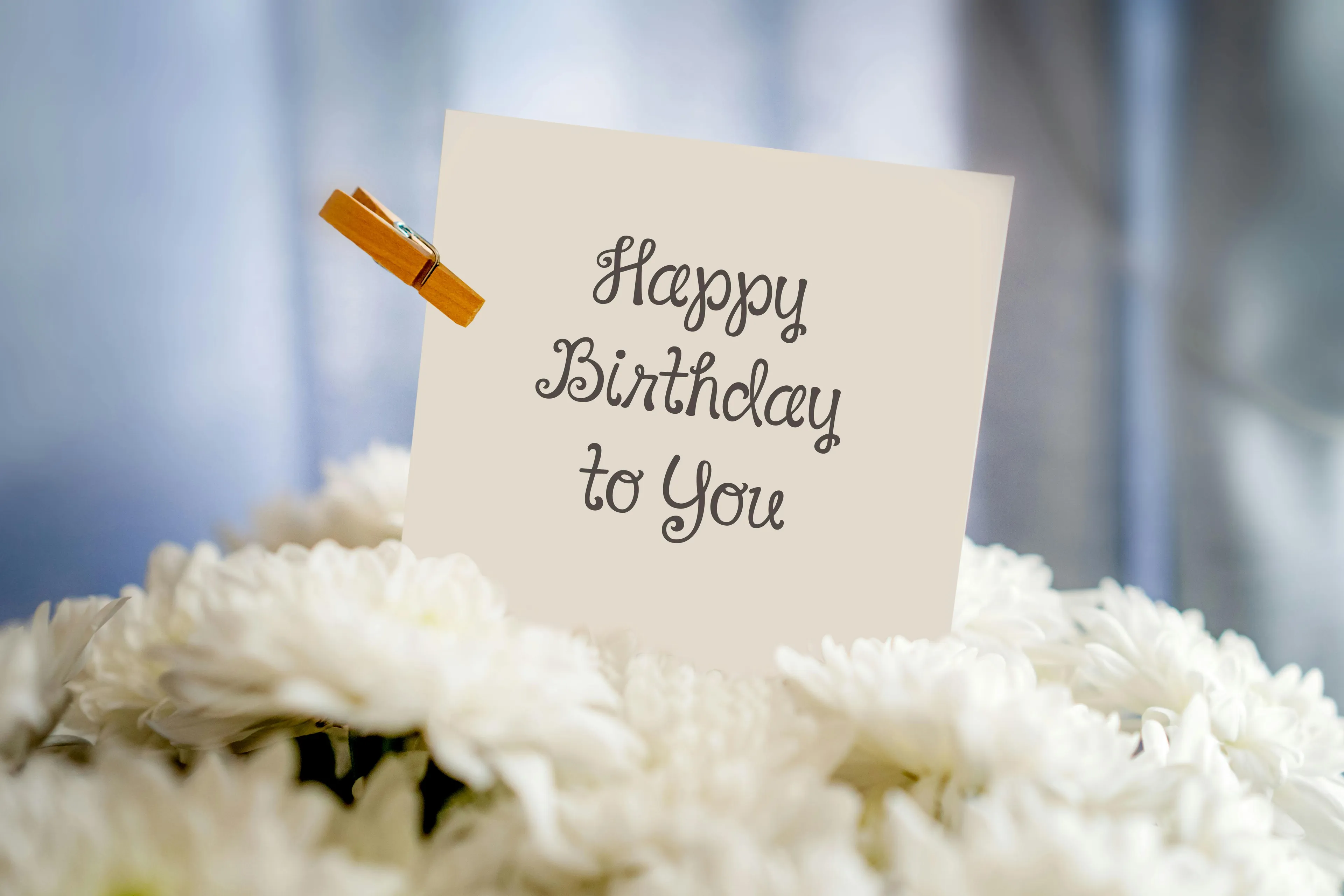 Birthday card riddle note clipped among white flowers, representing decision making style decoder concept.